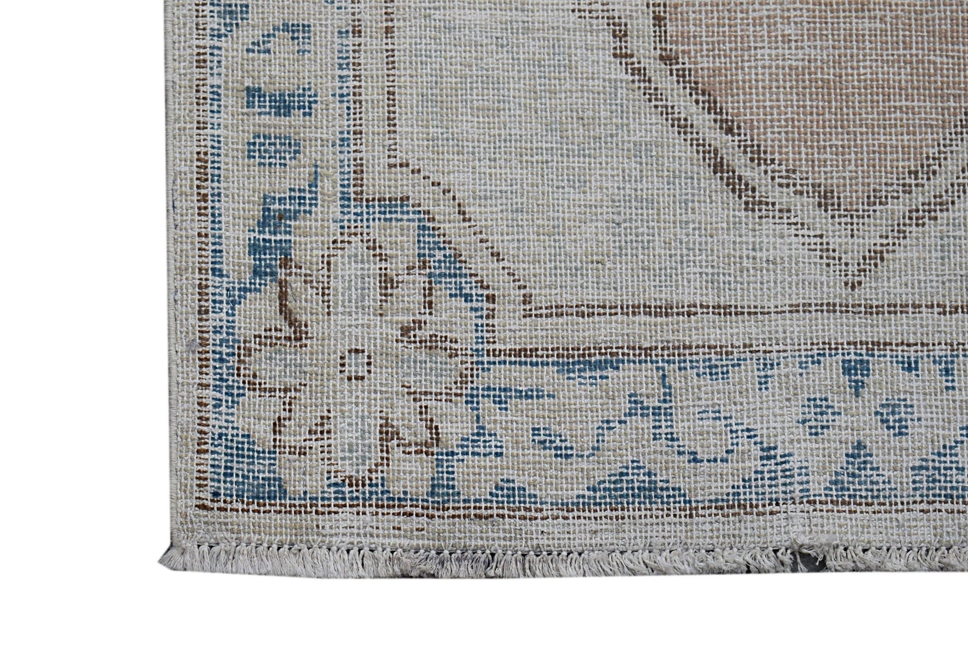 A close-up of a vintage Persian Kerman runner featuring a blue and beige floral medallion pattern.