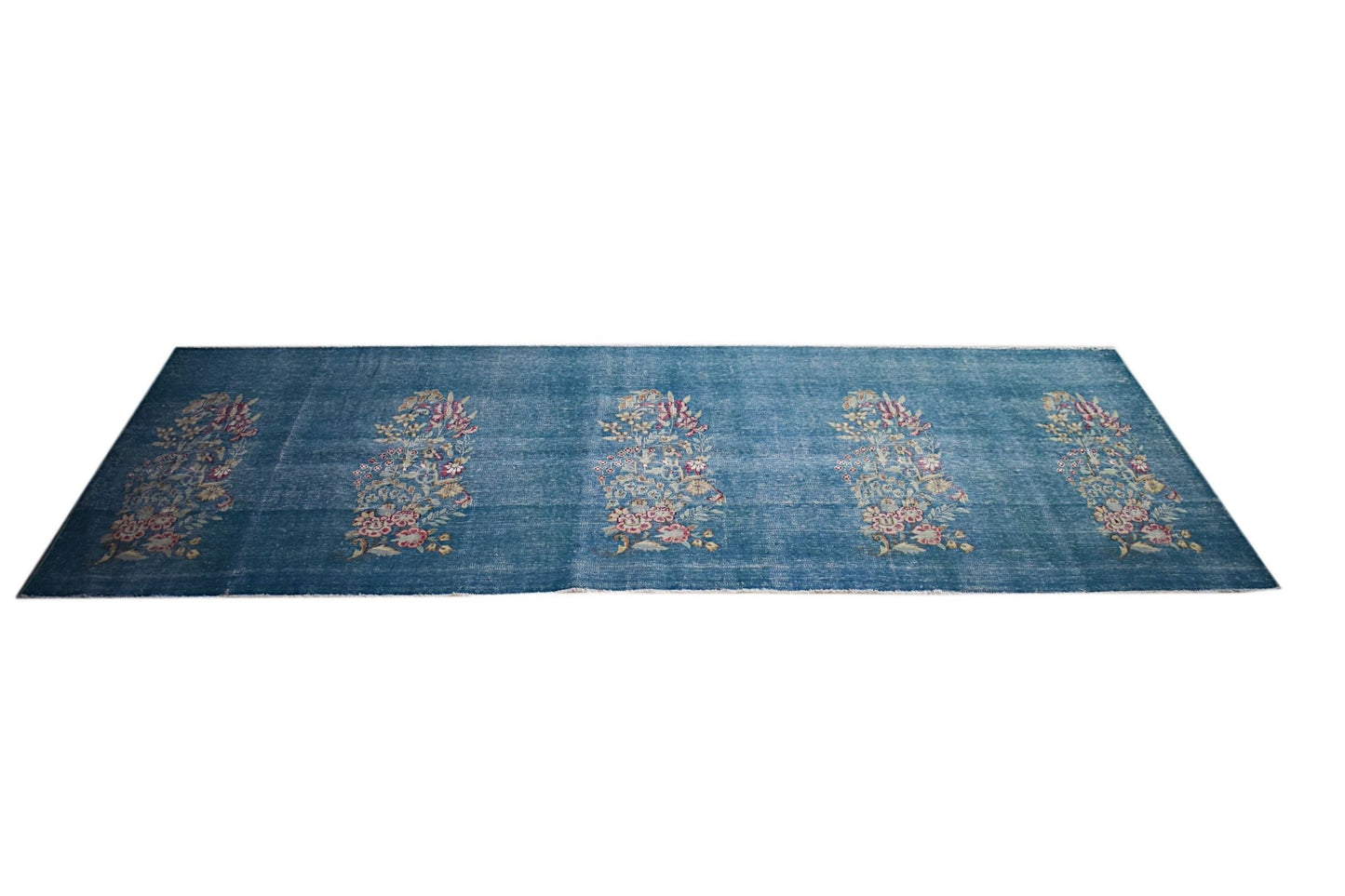 A vintage Persian Kerman runner featuring five floral bouquet motifs on a blue field.