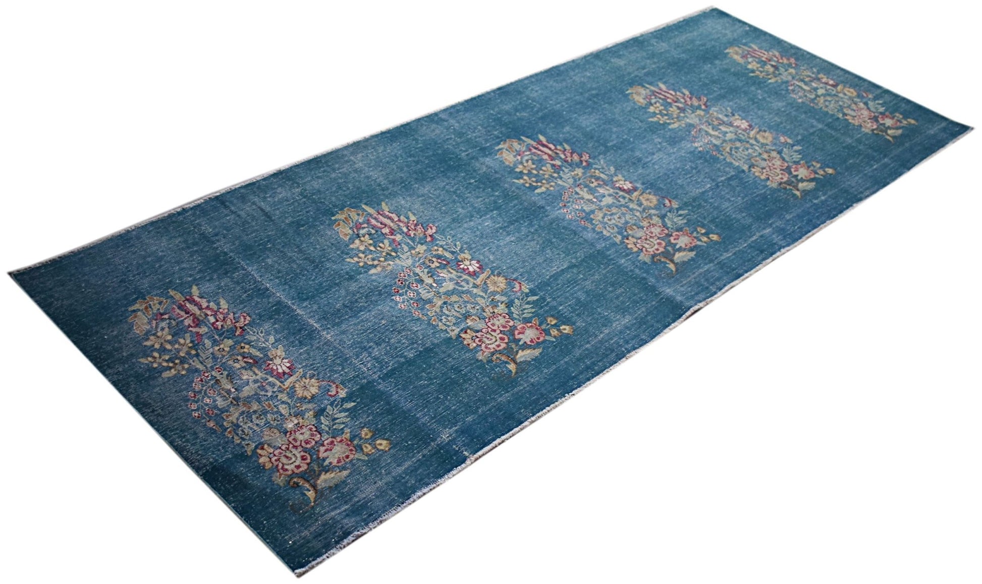 A vintage Persian Kerman runner featuring a blue field with repeating floral bouquet motifs.