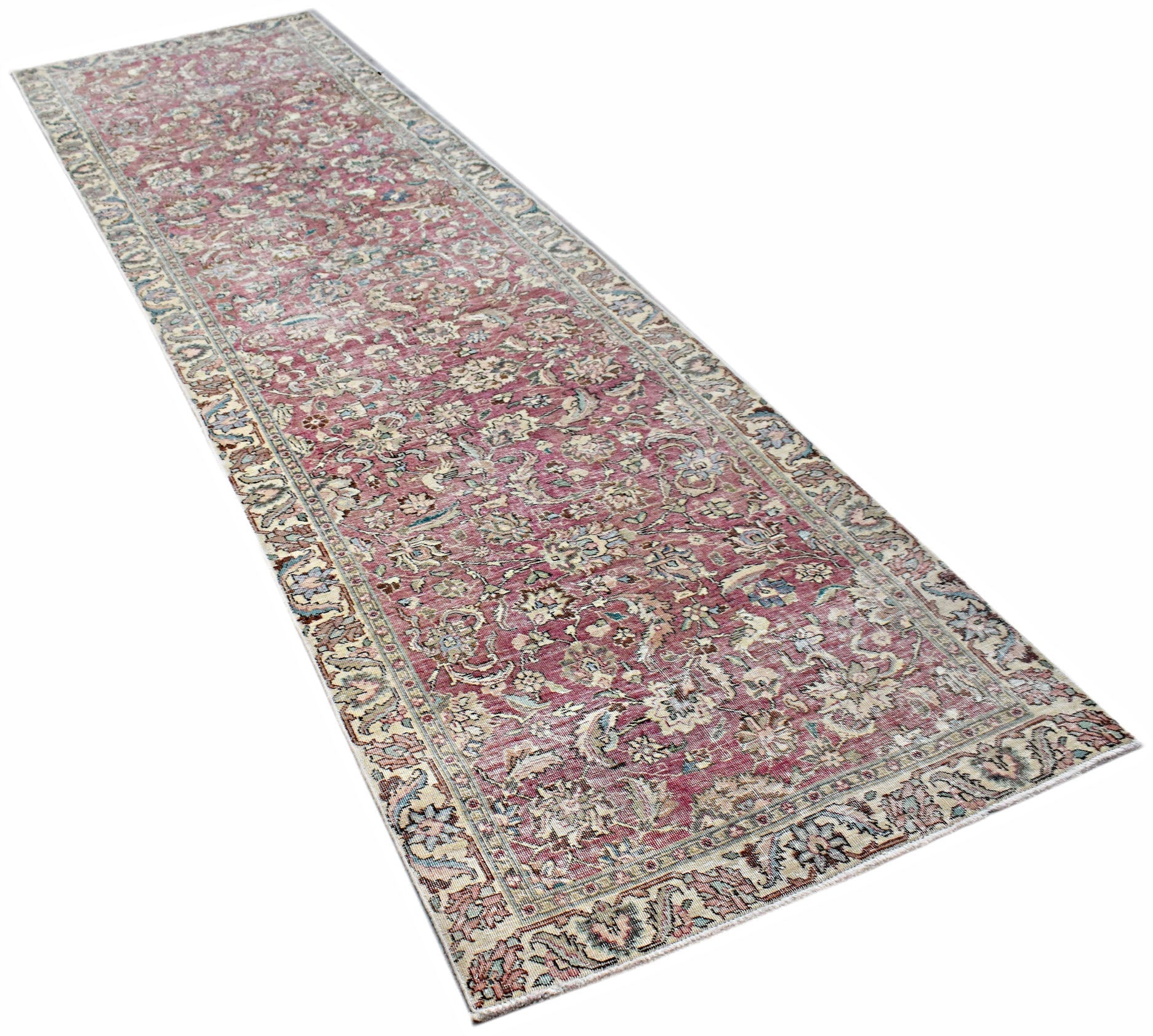 A vintage Persian Kerman runner rug featuring an intricate floral pattern in shades of pink and blue.