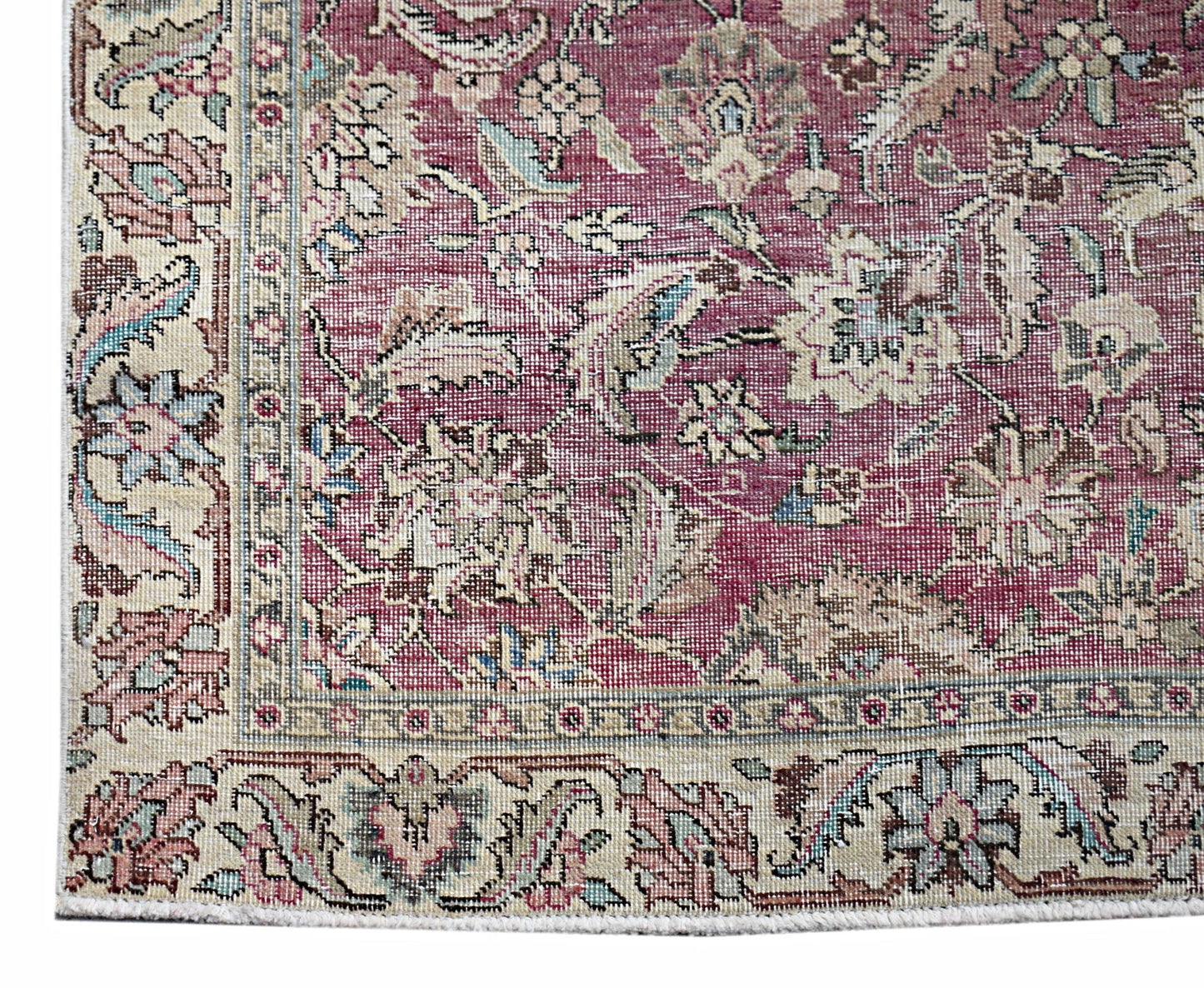 A vintage Persian Kerman runner featuring an intricate floral pattern in shades of red and cream.