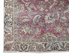 A vintage Persian Kerman runner featuring an intricate floral pattern in shades of red and cream.