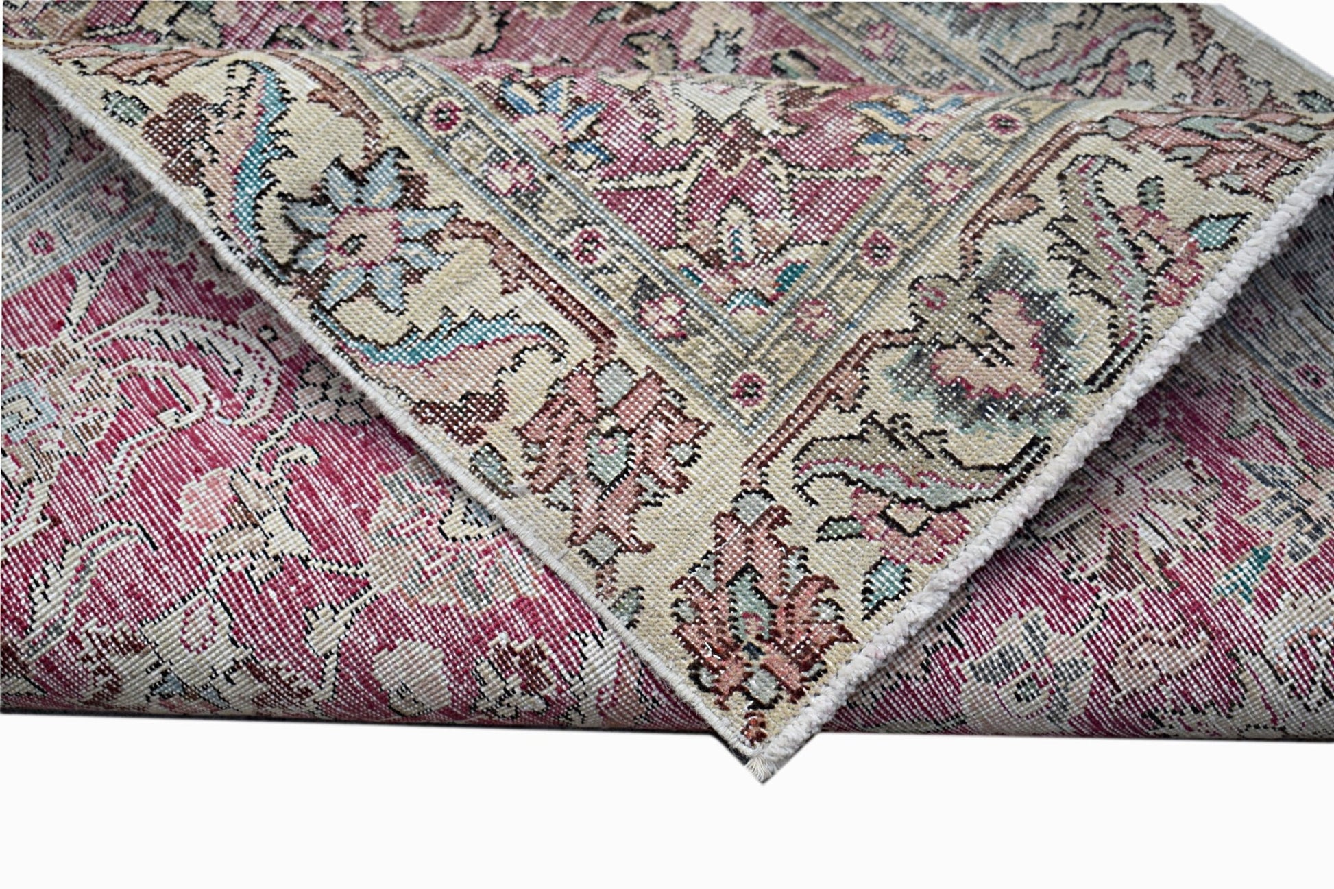 A vintage Persian Kerman runner featuring an intricate floral medallion design in pink and cream.