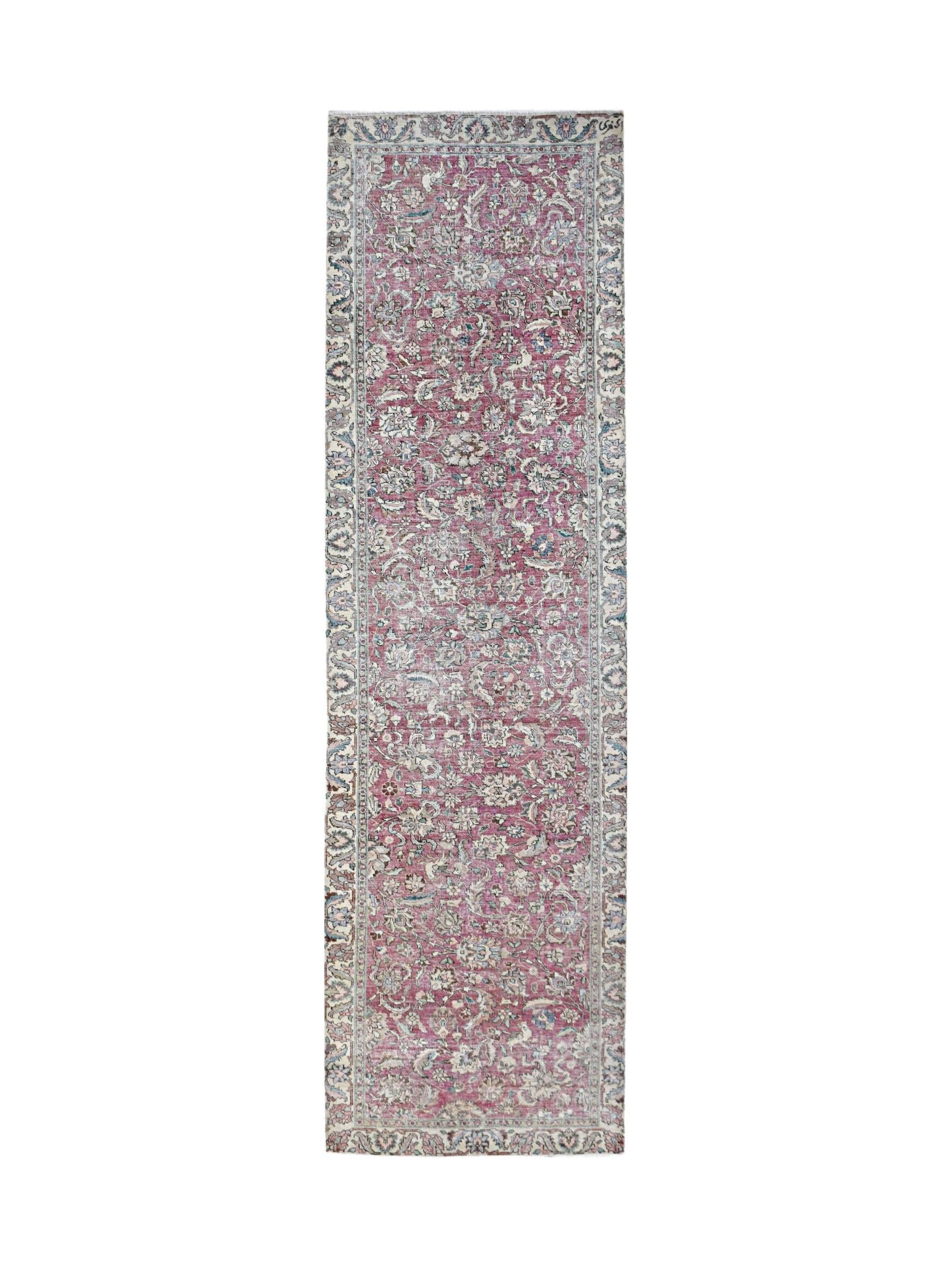 A vintage Persian Kerman runner featuring an intricate floral pattern in shades of pink and blue.