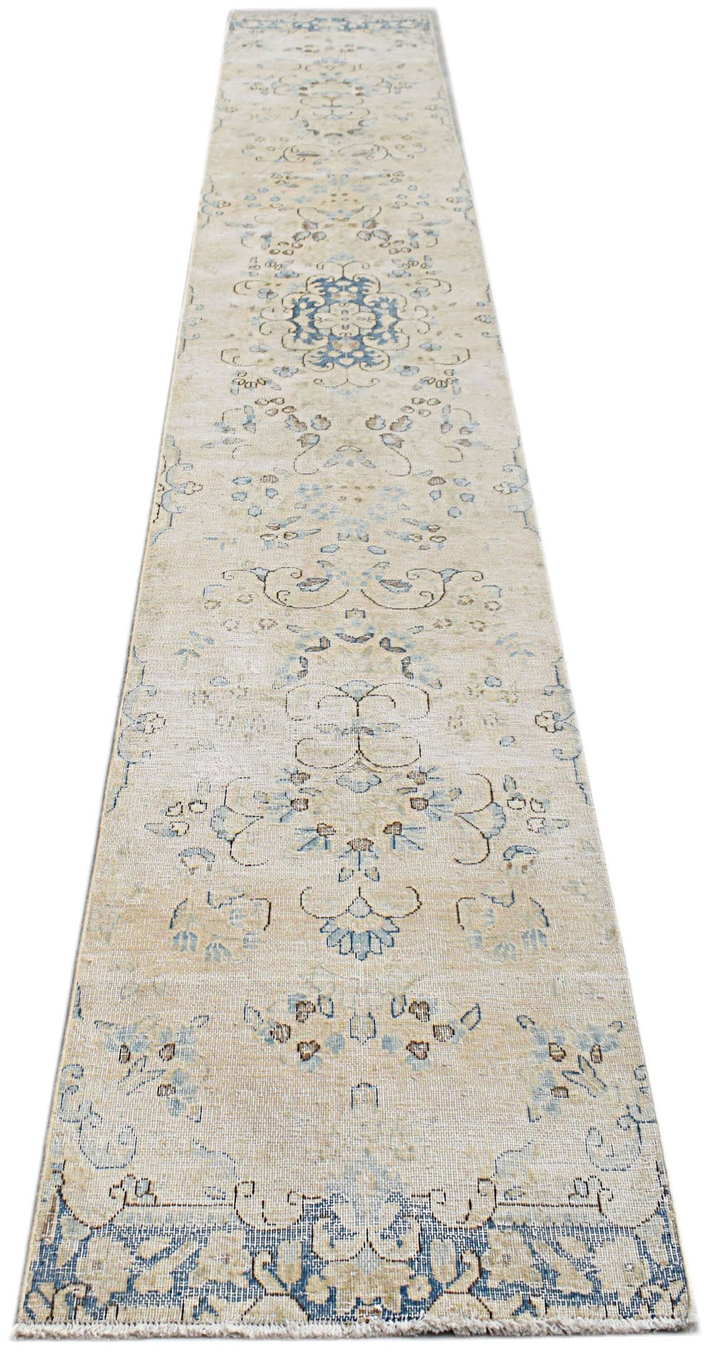 A vintage Persian Kerman runner featuring a floral medallion design in soft blue and beige tones.