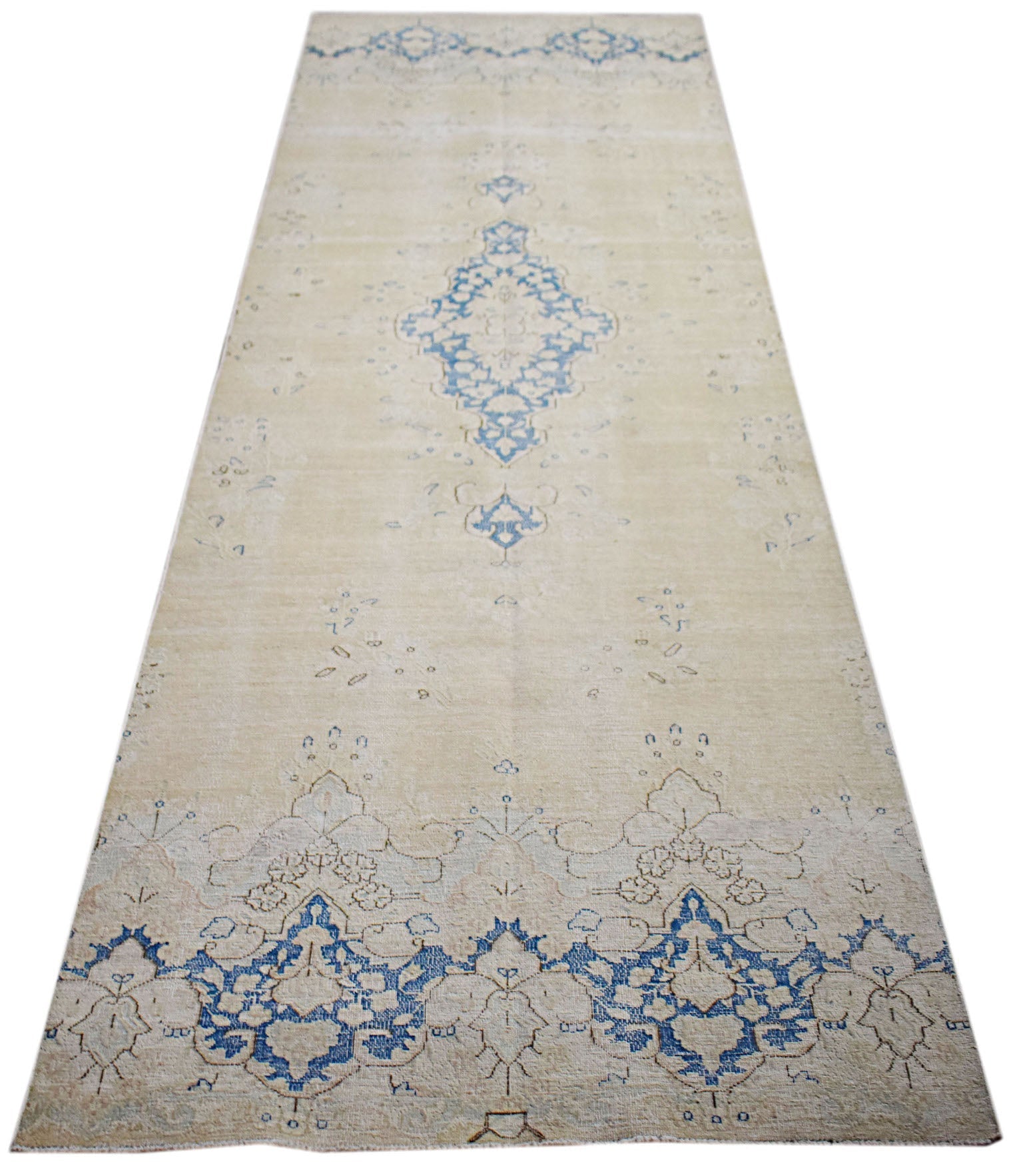 A vintage Persian Kerman runner featuring a central blue medallion on a light beige background.