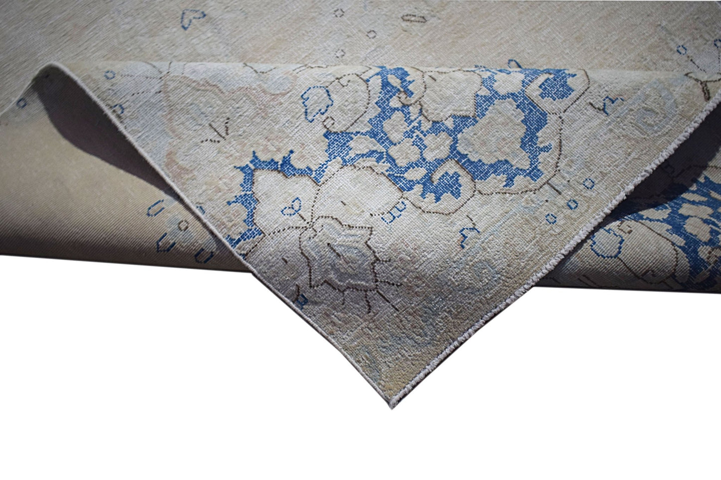 A vintage Persian Kerman runner featuring a blue floral medallion on a neutral beige background.