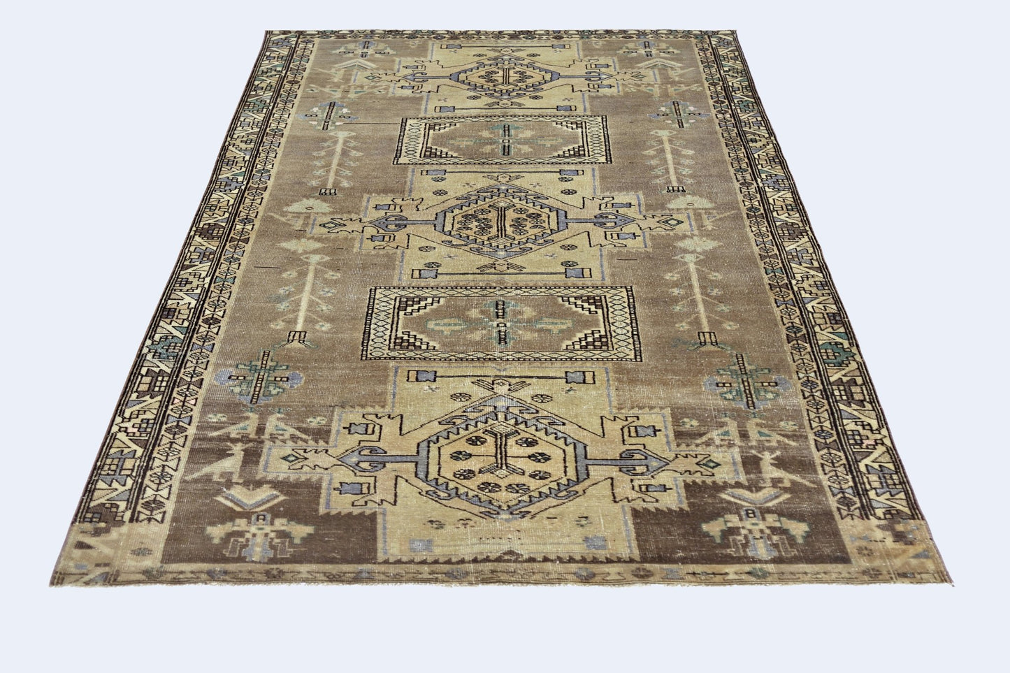 A vintage Persian rug featuring geometric patterns in shades of brown, blue, and cream.