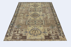 A vintage Persian rug featuring geometric patterns in shades of brown, blue, and cream.