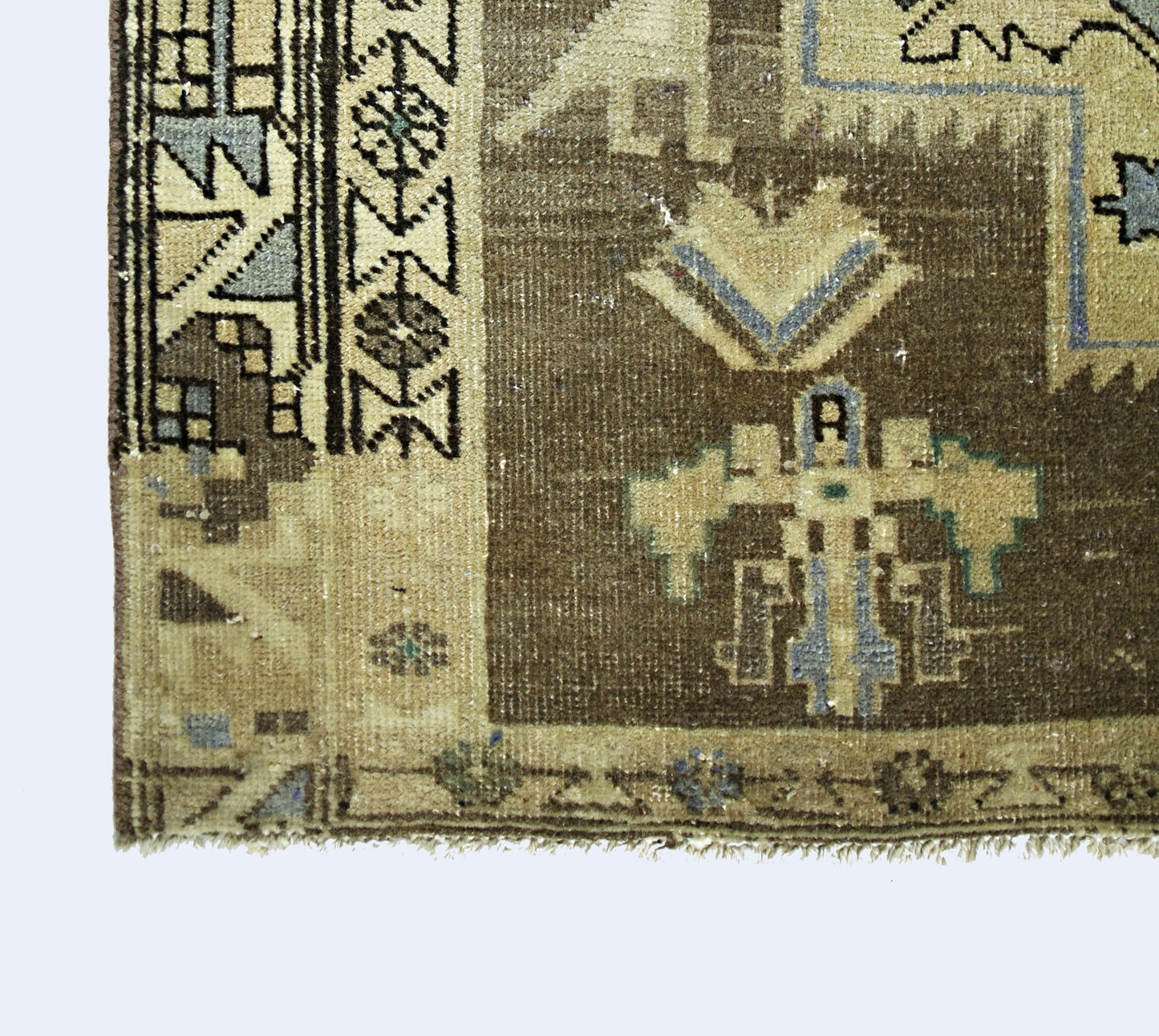 A vintage handmade Persian rug featuring geometric patterns in brown, beige, and blue tones.