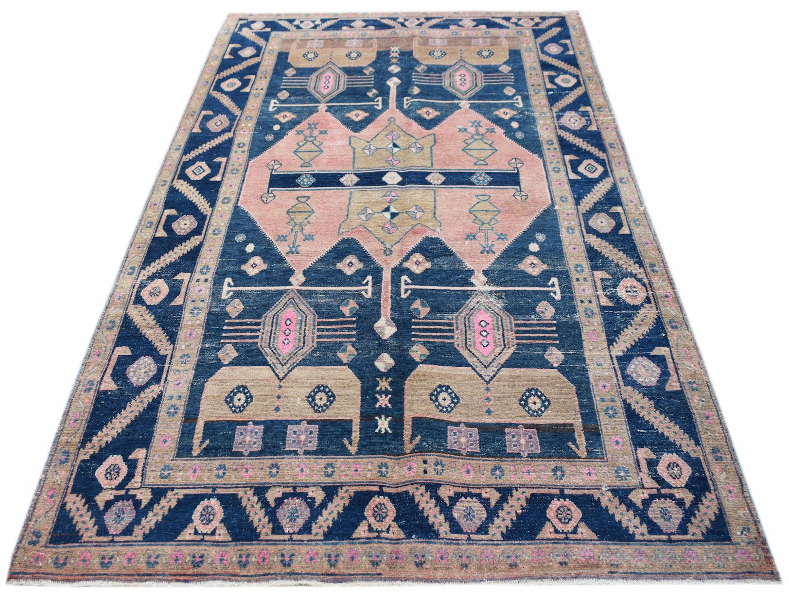 A vintage Persian Koliai rug featuring a geometric pattern in shades of blue, pink, and tan.