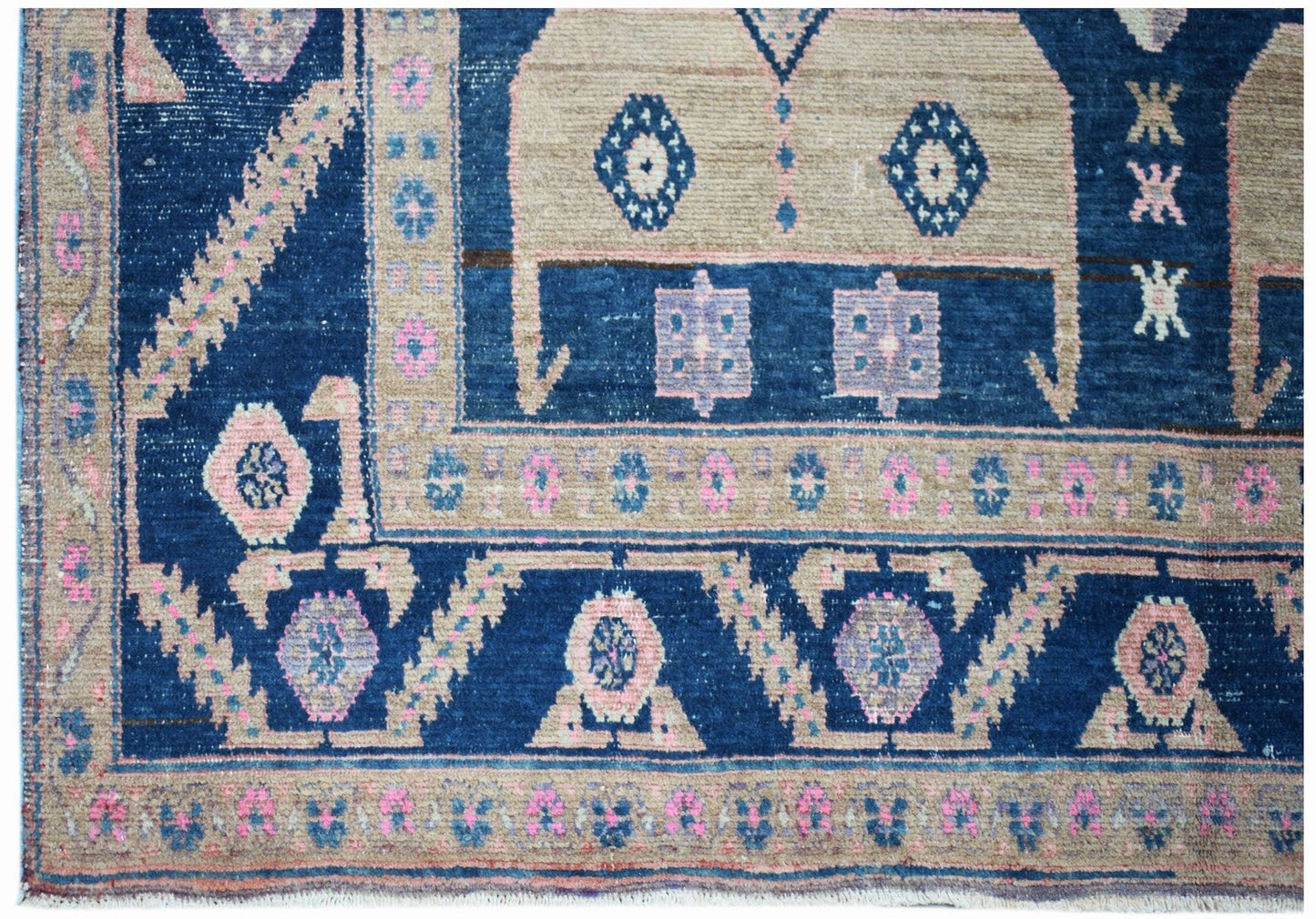 A handwoven vintage Persian Koliai rug featuring geometric patterns in blue, pink, and beige.