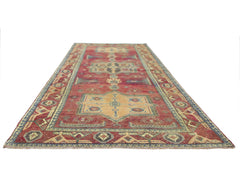 A vintage handmade Persian runner rug featuring geometric patterns in red, blue, and tan.