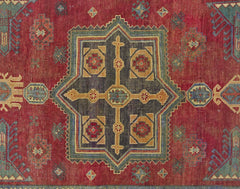 A vintage Persian rug featuring a central geometric medallion in red, blue, and gold tones.