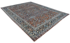 A vintage Persian Lori rug featuring an intricate floral pattern in rust, blue, and black tones.