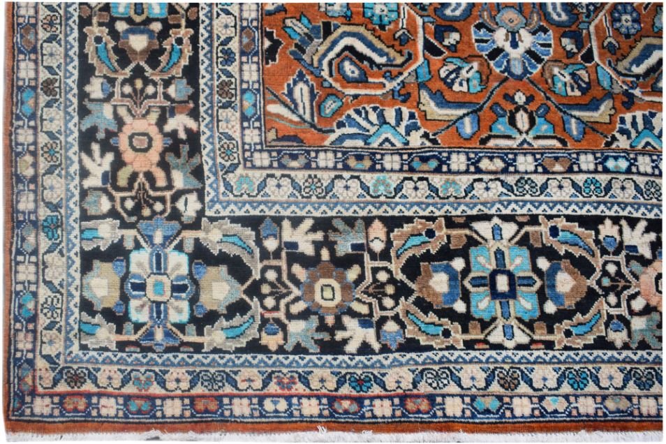 A vintage Persian Lori rug featuring intricate geometric and floral patterns in blue and orange.