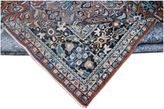 A vintage Persian Lori rug featuring intricate floral patterns in blue, black, and rust tones.