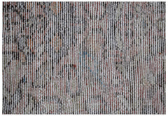A close-up view of a vintage handwoven runner rug featuring a faded floral pattern in wool.