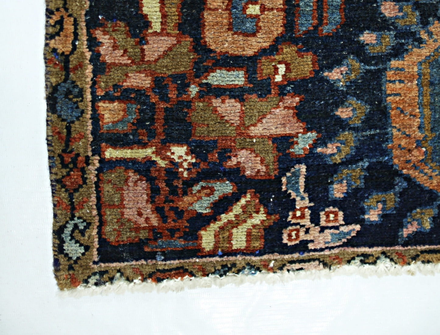 A corner view of a vintage Persian Malayer runner featuring intricate floral patterns in wool.