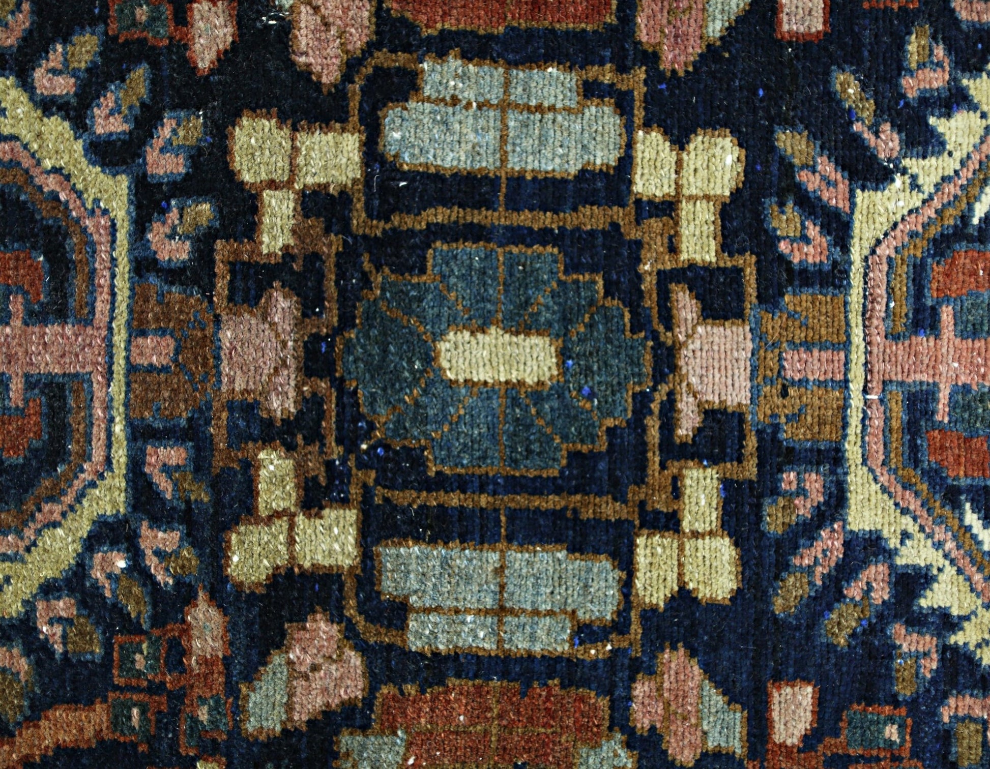A close-up of a vintage Persian Malayer runner featuring intricate geometric patterns in wool.