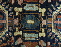 A close-up of a vintage Persian Malayer runner featuring intricate geometric patterns in wool.