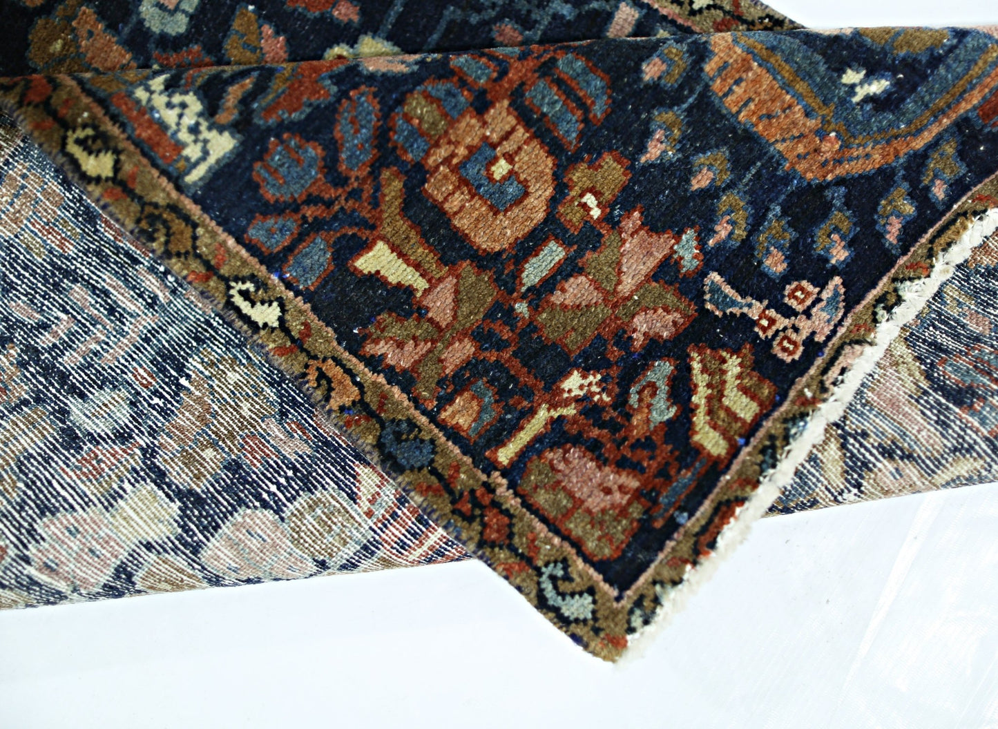 A vintage Persian Malayer runner with a dark blue field and intricate geometric floral patterns.