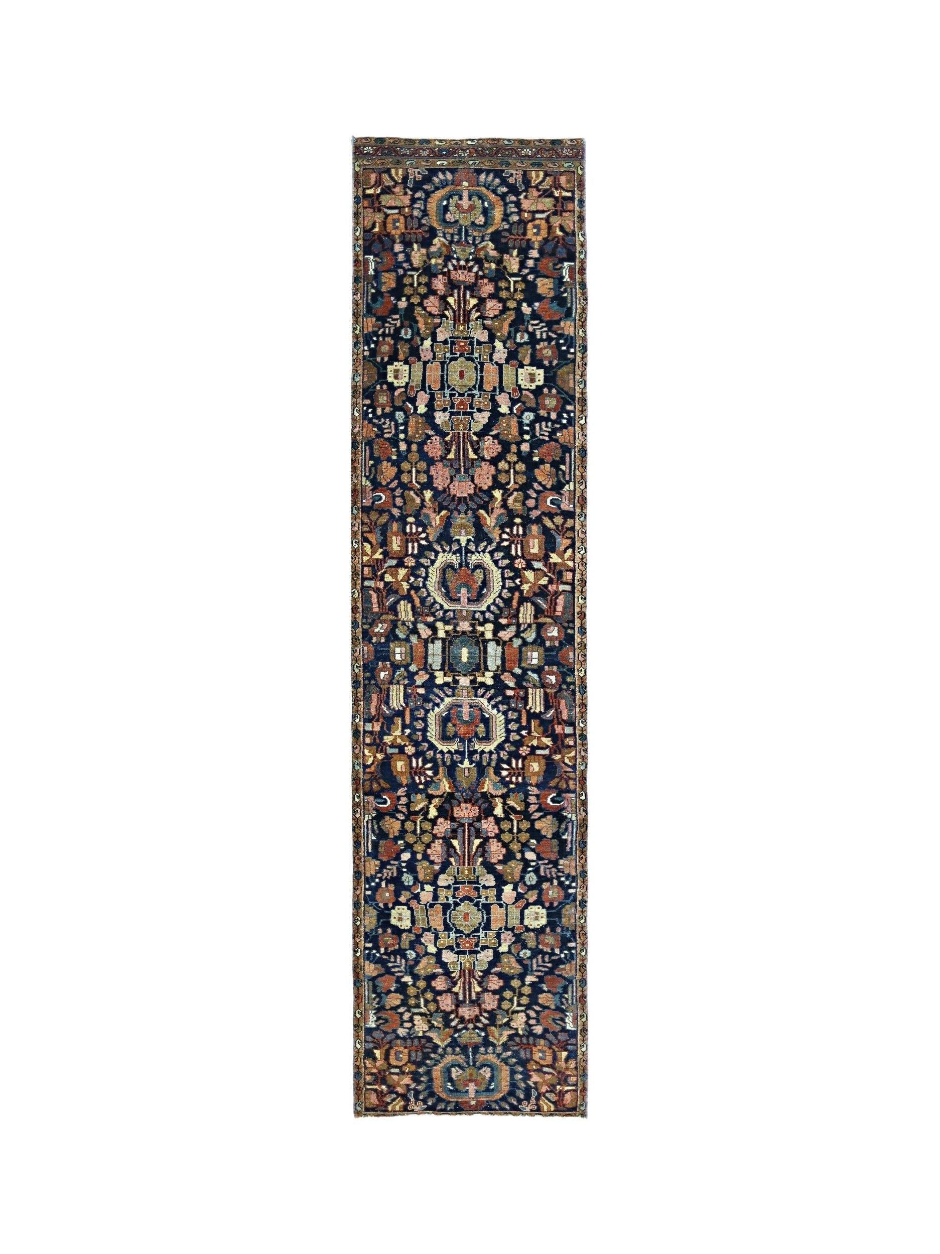 A vintage Persian Malayer runner featuring a floral pattern in muted tones on a dark blue field.