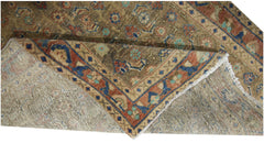 A vintage Persian Hamadan runner with a folded corner showing its wool pile and cotton foundation.