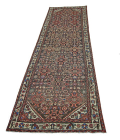 A vintage Persian Hamadan runner rug featuring a detailed geometric pattern in red and blue tones.