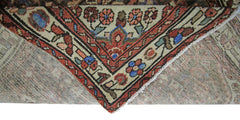 A corner of a vintage Persian Hamadan runner showing its intricate floral pattern and wool weave.