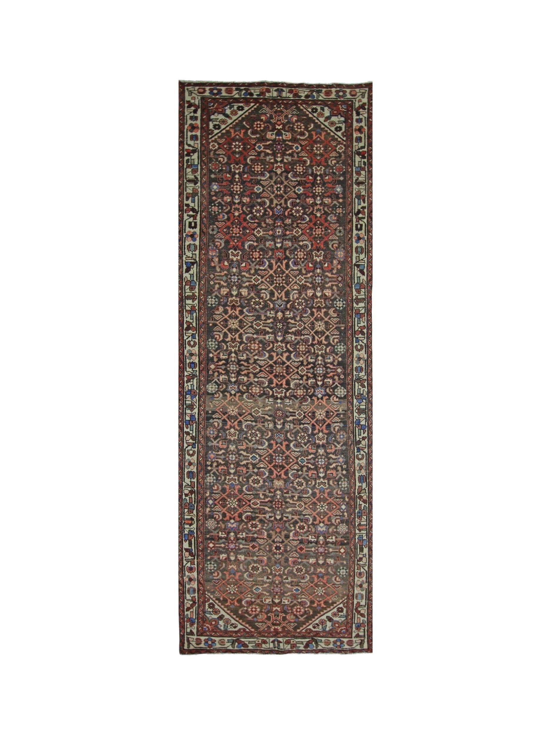 A vintage Persian Hamadan runner featuring a dark field with intricate geometric floral patterns.