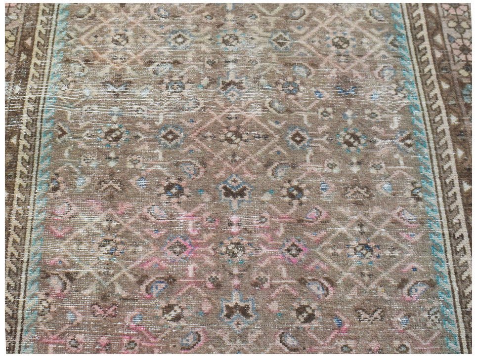 A vintage Persian Hamadan runner featuring a faded brown geometric pattern with blue and pink accents.
