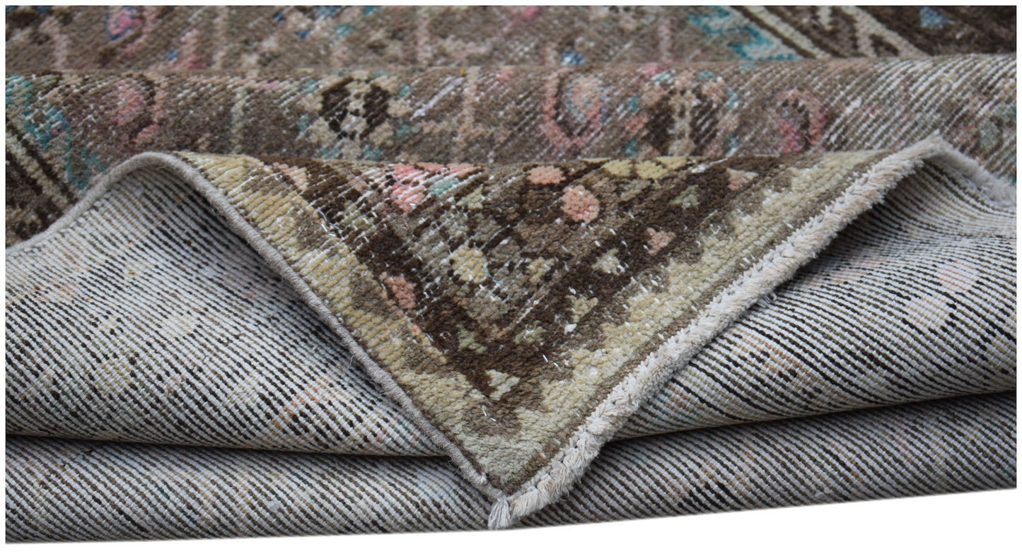 A folded vintage Persian Hamadan runner featuring a worn, patterned wool pile on a cotton base.