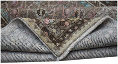 A folded vintage Persian Hamadan runner featuring a worn, patterned wool pile on a cotton base.