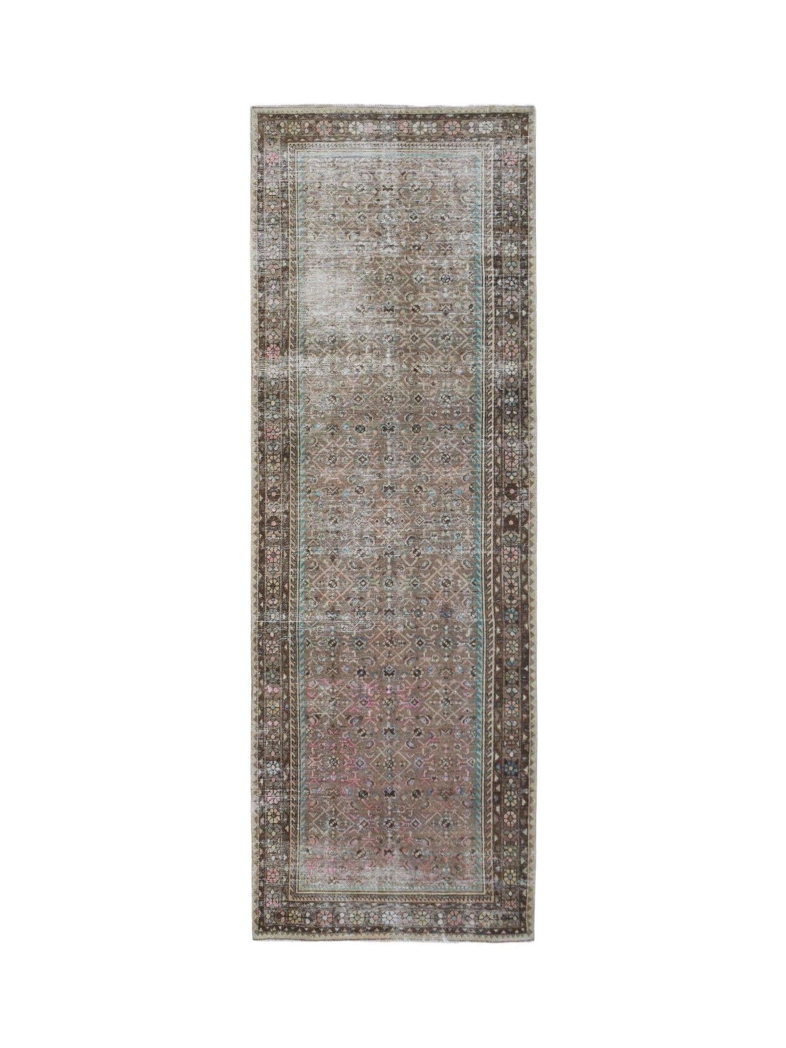 A vintage Persian Hamadan runner rug featuring a faded geometric pattern in brown, pink, and blue.