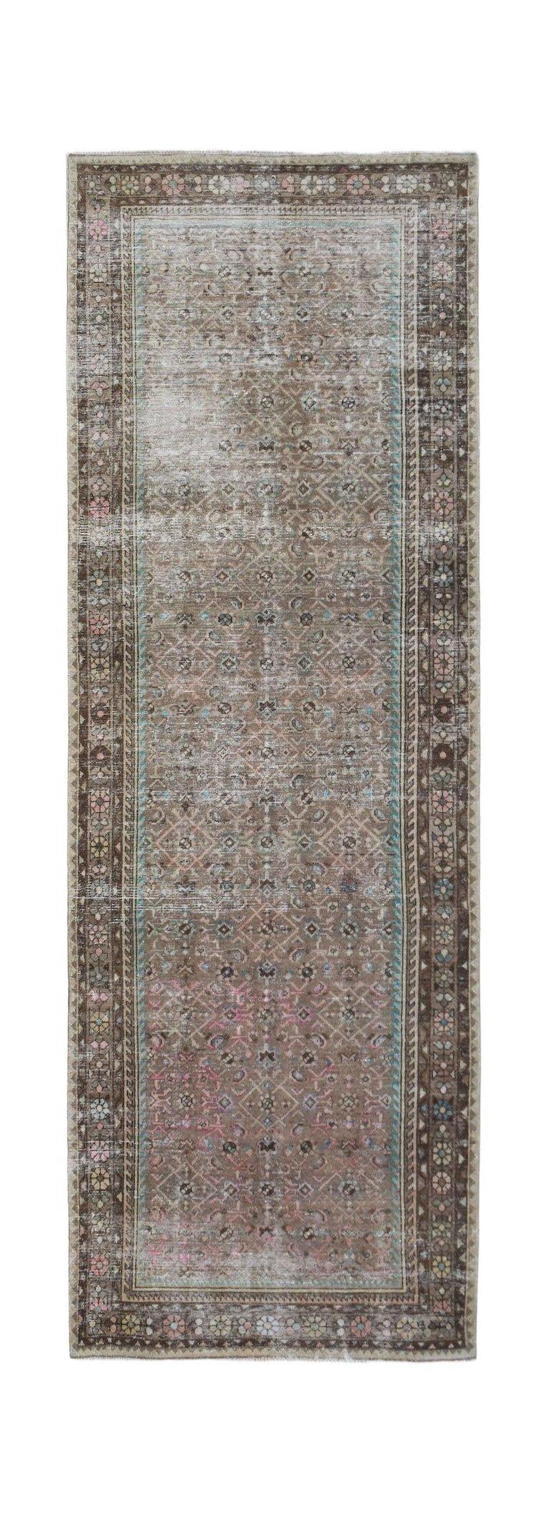 A vintage Persian Hamadan runner rug featuring a faded geometric pattern in brown, pink, and blue.