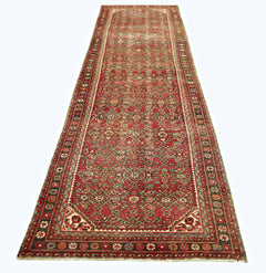 A vintage Persian Hamadan runner rug featuring a red field with intricate geometric patterns.