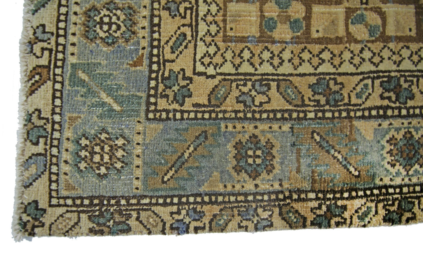A close-up of a vintage Persian Malayer runner featuring intricate geometric patterns in blue and tan.