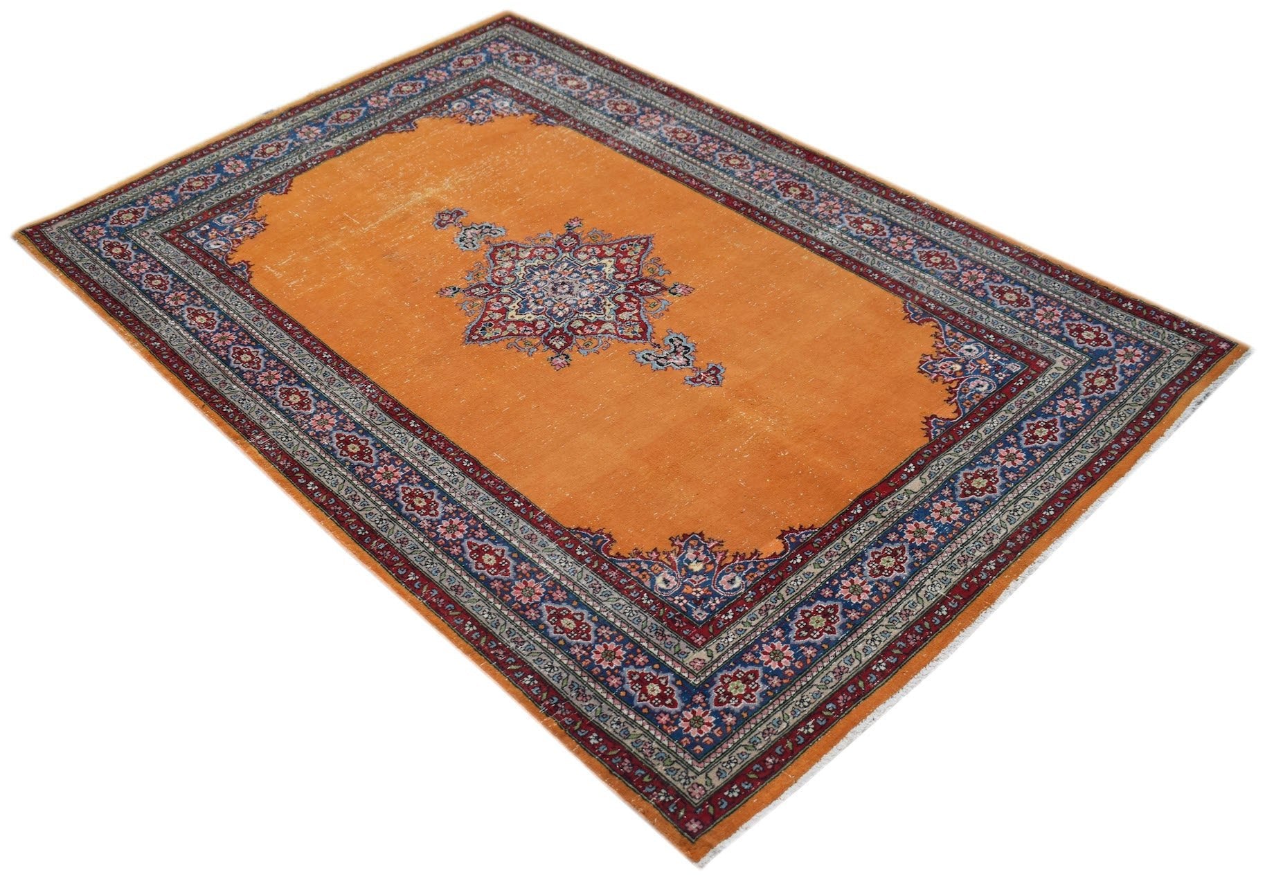 A vintage handwoven Persian Mashad rug featuring a central floral medallion on a bright orange field.