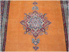 A vintage Persian Mashad rug featuring a central floral medallion on a bright orange field.