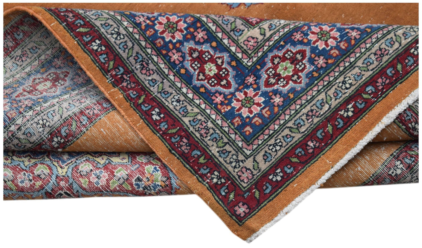 A vintage Persian Mashad rug featuring a vibrant orange field and intricate floral blue borders.