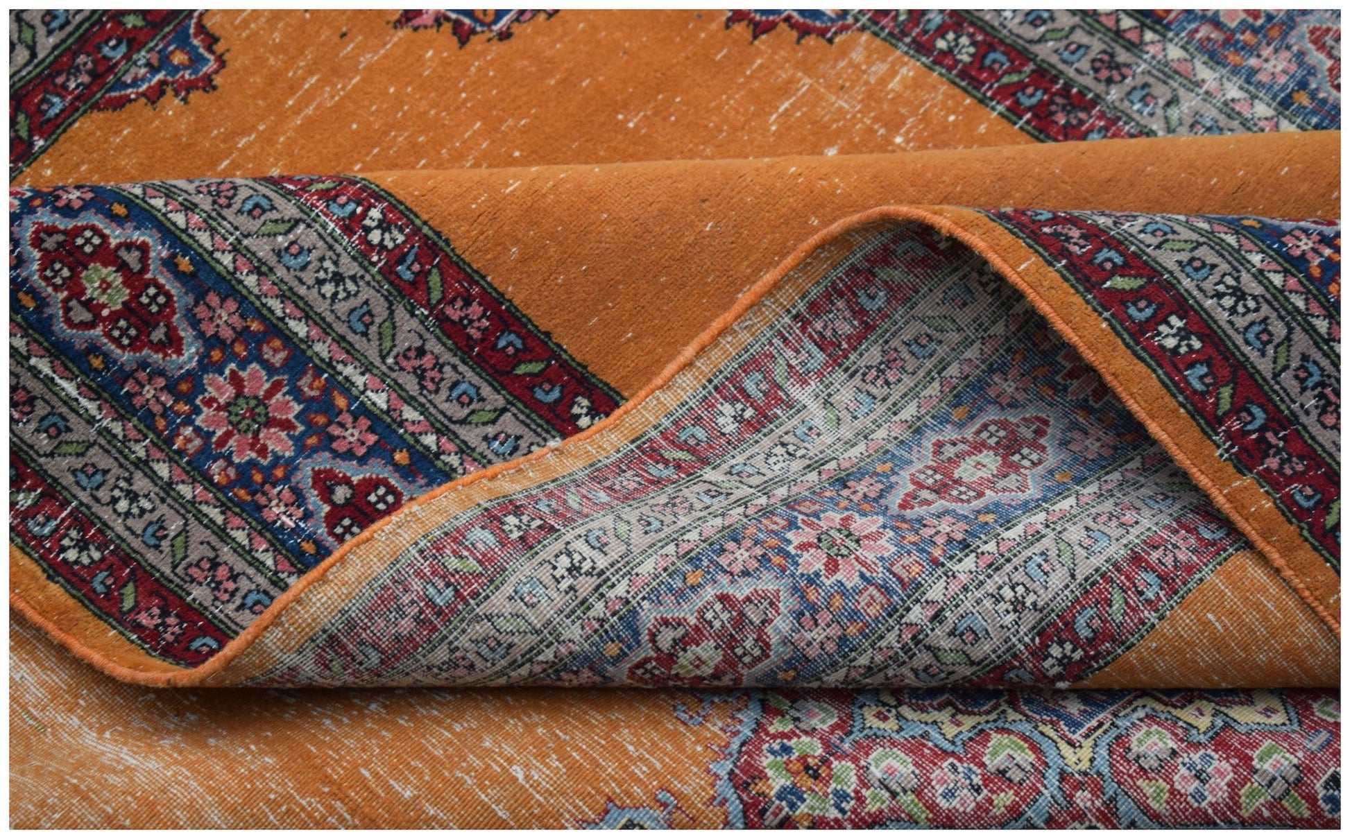 A vintage Persian Mashad rug featuring a vibrant orange field with intricate floral patterns.