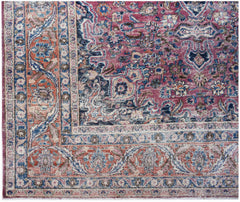 A vintage Persian Mashhad rug featuring intricate floral patterns in shades of pink, blue, and red.