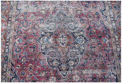 A vintage Persian Mashhad rug featuring a central floral medallion in shades of red and blue.