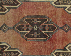 A vintage Persian Mazlaghan rug featuring a geometric medallion pattern in rust and dark brown.