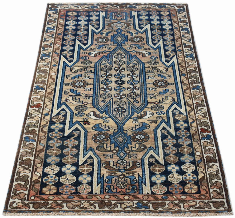 A vintage handwoven Persian Mazlaghan rug featuring a geometric blue and tan medallion pattern.