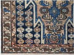 A vintage Persian Mazlaghan rug featuring geometric floral patterns in blue, brown, and tan.