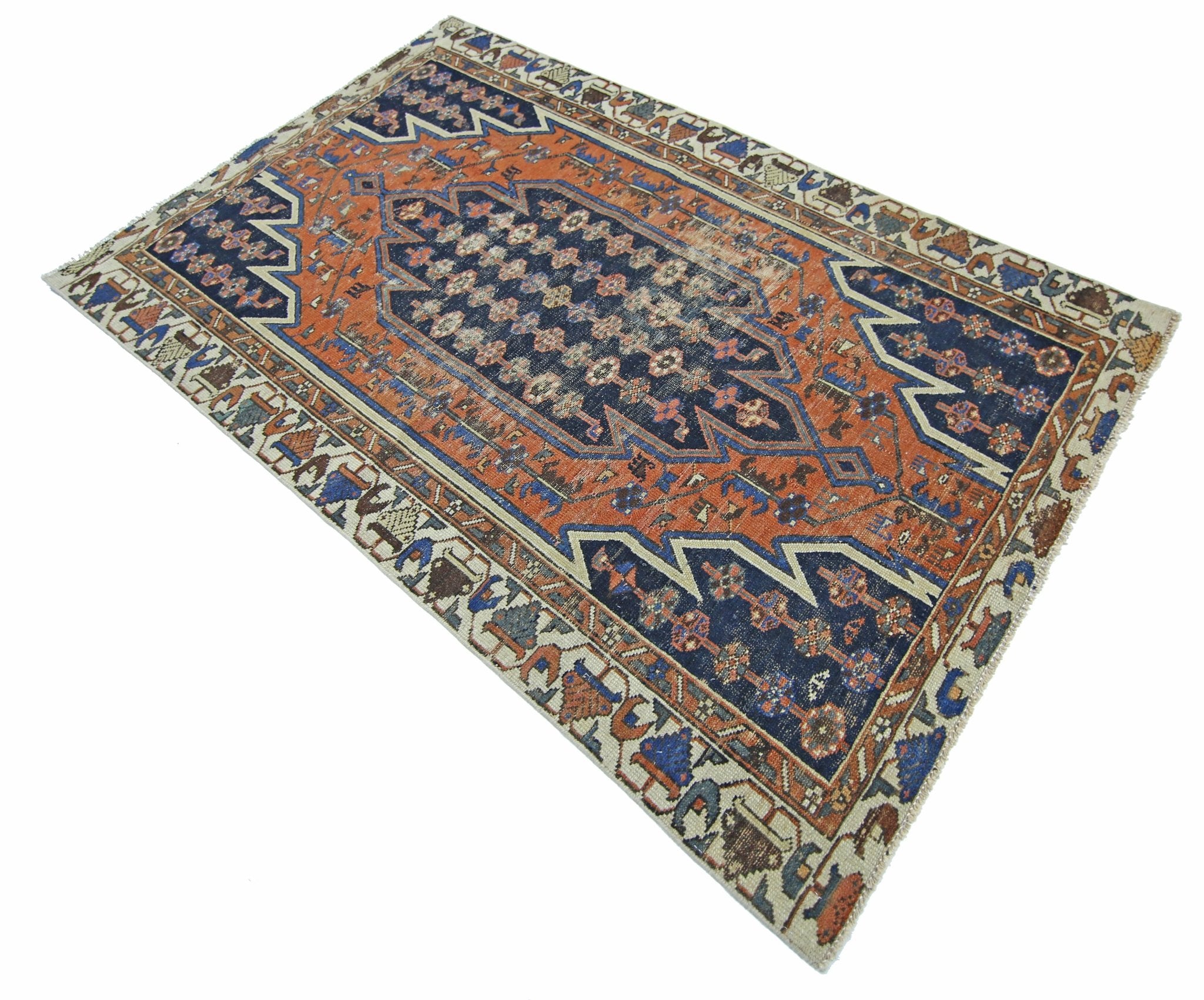 A vintage Persian Mazlaghan rug featuring a geometric medallion pattern in blue and orange tones.