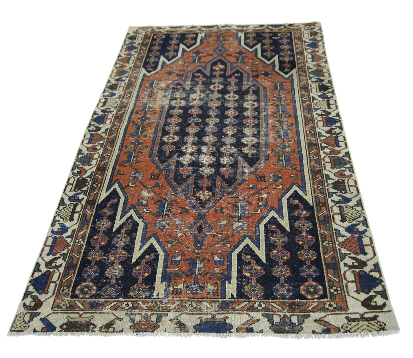 A vintage Persian Mazlaghan rug featuring a geometric navy and orange pattern on a cream border.