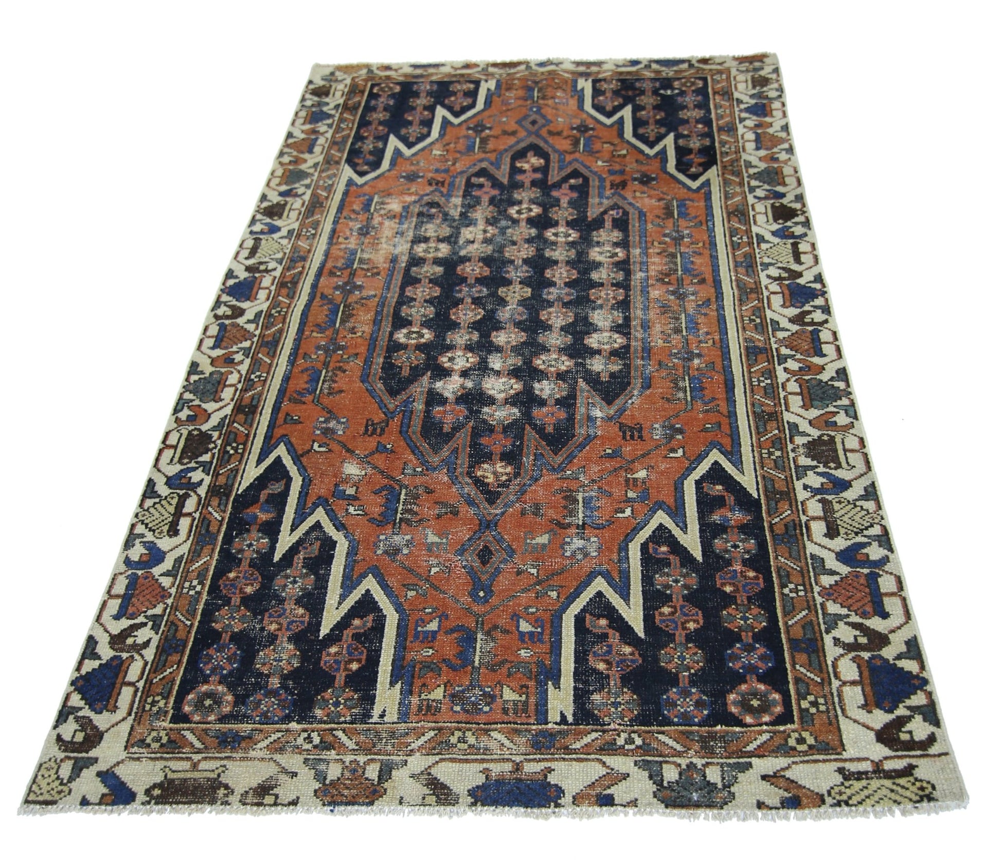A vintage Persian Mazlaghan rug featuring a geometric navy and orange pattern on a cream border.